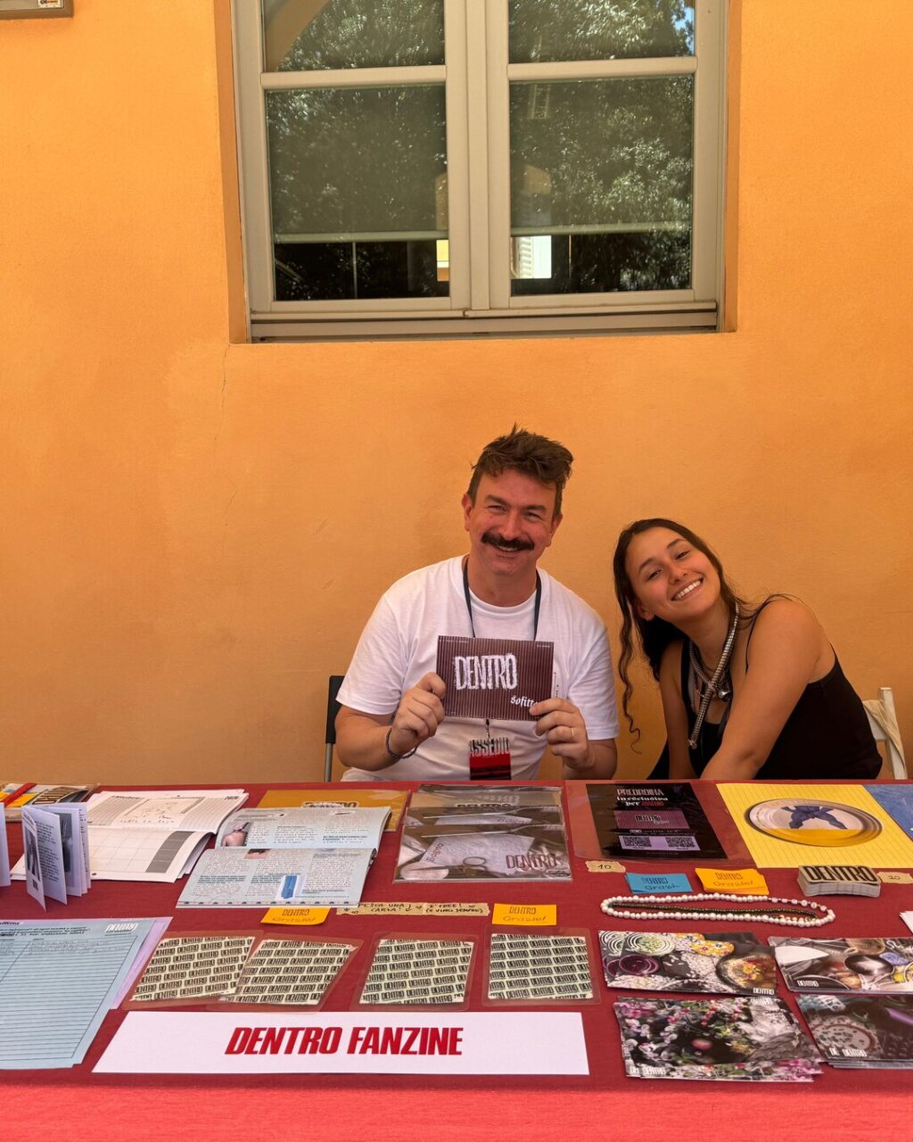 The DENTRO Fanzine stall at Assedio in Modena, with the zines and the editorial team