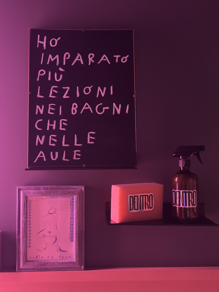The bathroom at Casa Frida with the sign “Ho imparato più lezioni nei bagni che nelle aule” and the DENTRO Bathroom zine